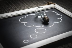 Light bulb on chalkboard with thought bubble drawing