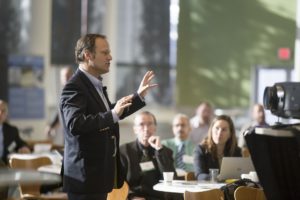 Man giving a presentation to a seated audience in a conference room