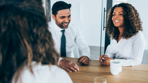 Group of diverse colleagues in a meeting room discussing and smiling