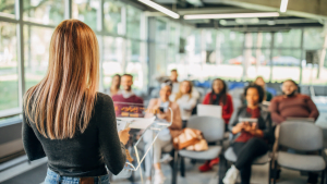 Woman presenting to diverse group of people seated in conference room with natural light