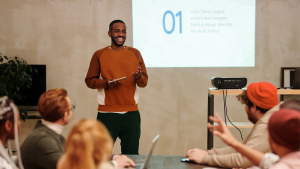 Man giving presentation to colleagues in modern office, business training and professional development