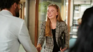 Smiling businesswoman shaking hands with a colleague in a professional office environment