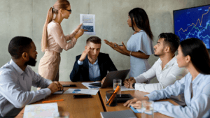 Business team discussing data charts in meeting room with frustrated man