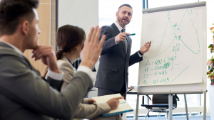 Professional business meeting with man presenting data on flip chart to colleagues