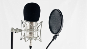 Professional studio microphone with pop filter on white background, ready for recording or podcasting