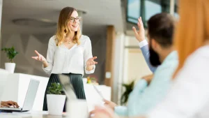 Young woman speaking in a business meeting with colleagues in modern office