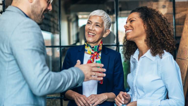 Three colleagues engaged in a positive discussion inside a stylish office space