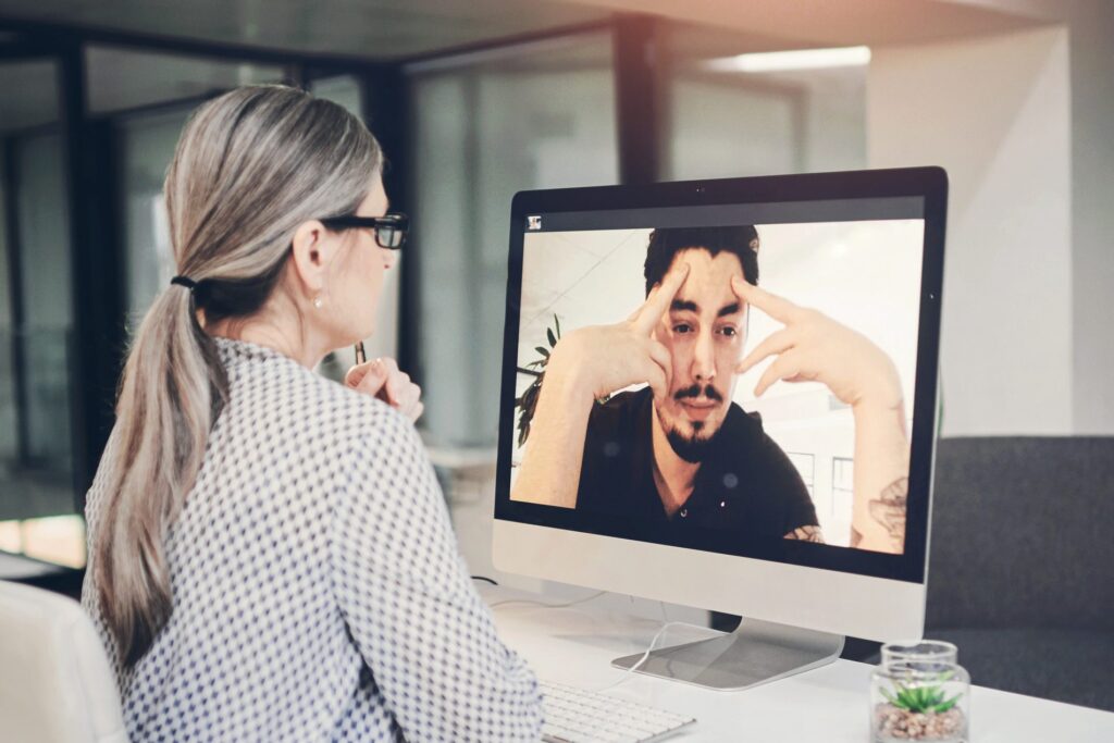 Facilitator listens calmly while a frustrated participant speaks on a video call