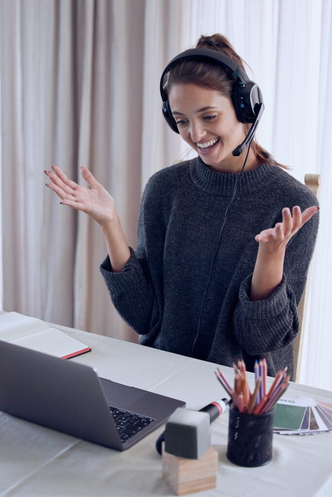 Trainer with a headset microphone gestures toward her webcam while asking the group a question