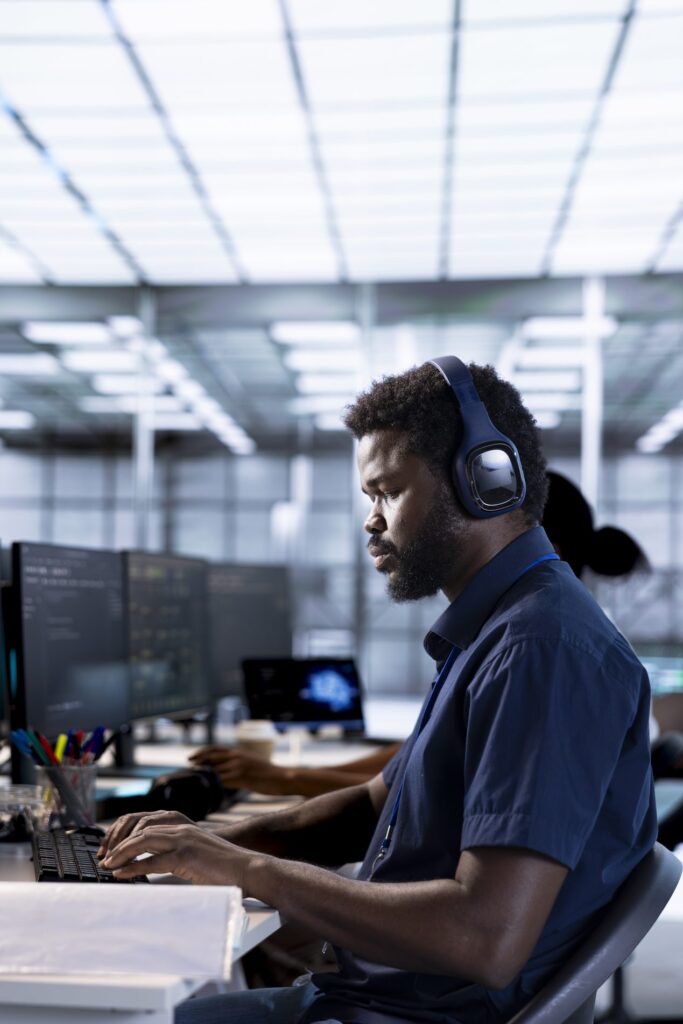 Producer in headphones works across several monitors to support a live session