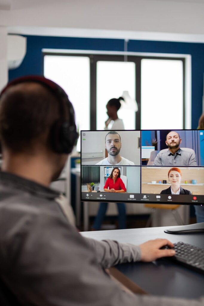 Facilitator wearing a headset runs a live online session with four participants on screen